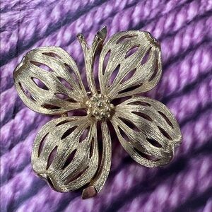 This is a vintage gold-toned dogwood flower brooch.